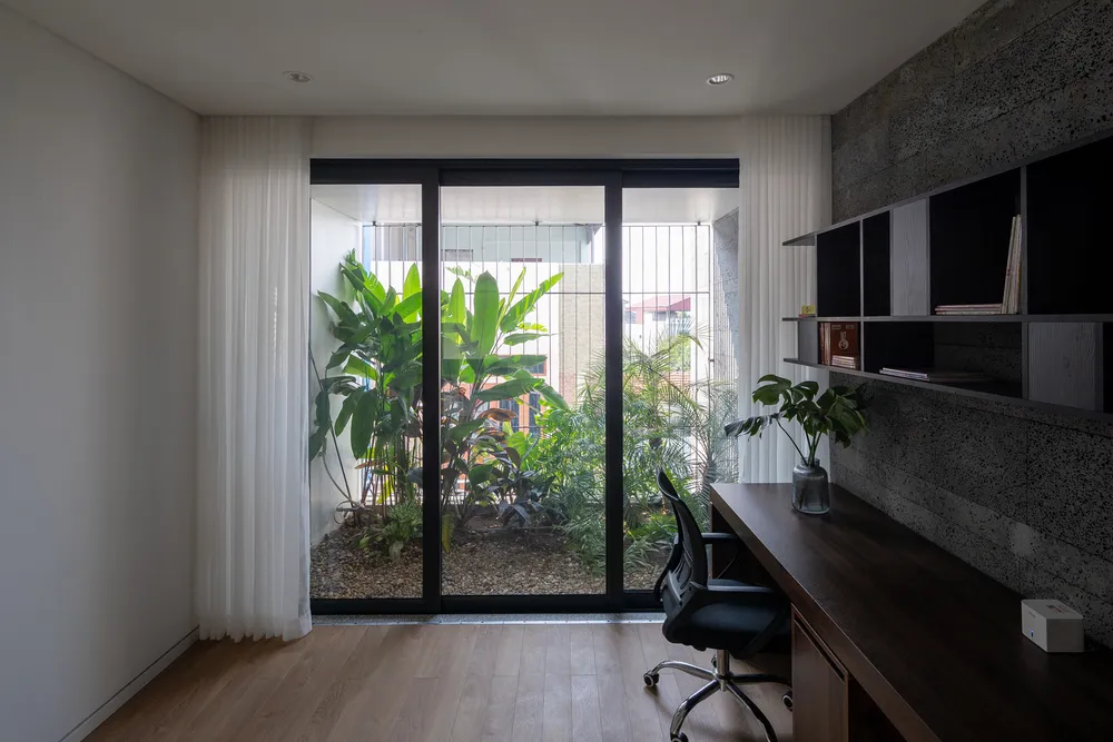 Phòng làm việc kết nối chặt chẽ với cây cối bên ngoài thông qua cửa kính trong suốt.
