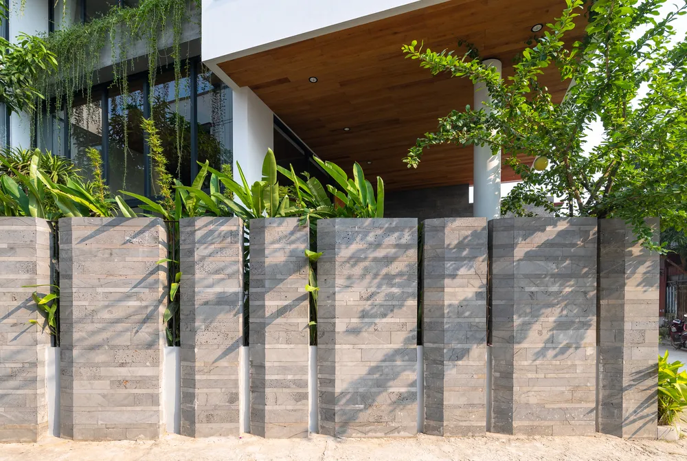 Kiến trúc sư HA&amp;A Design khéo léo ốp đá ong lớn vào bức tường chính của ngôi nhà, đóng vai trò như một vách ngăn giữa ngôi nhà và công trình bên cạnh.