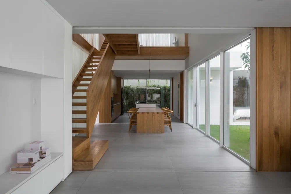 Phòng ăn với khoảng giếng trời và hành lang gỗ nối phía trên giúp tăng cường sự tương tác.