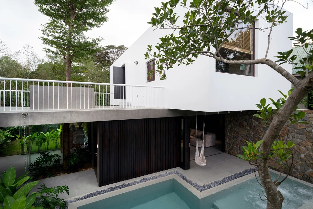 Kiến trúc sư chia sân vườn thành hai phần, phía trước là lối vào với bãi đậu xe, bể bơi, tiệc ngoài trời; phía sau là vườn trồng rau và cây ăn trái.