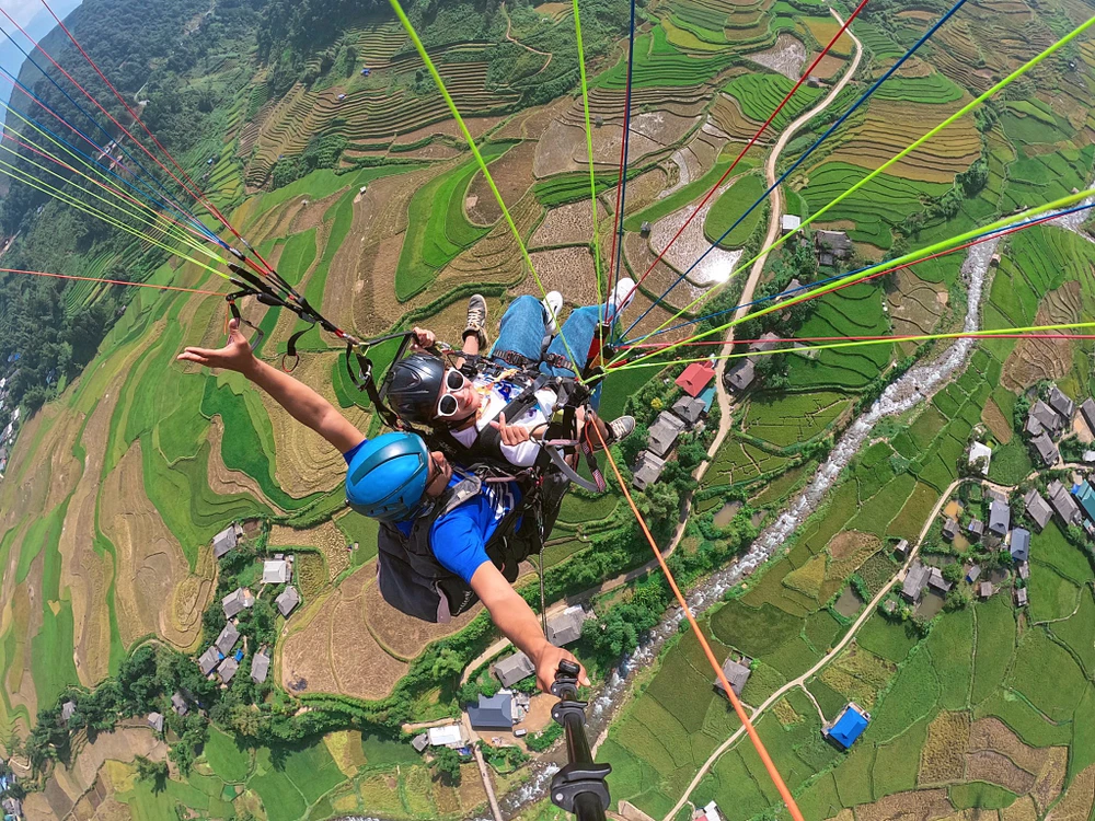 Du khách bay dù lượn trên mùa lúa vàng ở đèo Khau Phạ.
