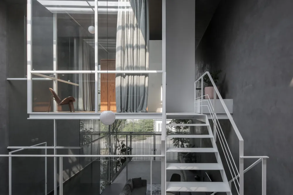 Đi cùng với khoảng trống trên mái, gạch thông gió phía sau và lưới sắt phía trước mang ánh sáng tự nhiên vào nhà.