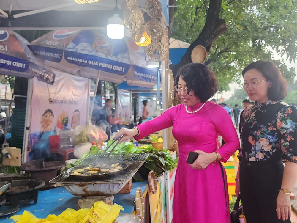 Lãnh đạo UBND quận 1 tham quan, trải nghiệm gian hàng bánh xèo, bánh khọt. Ảnh: THU TRINH.