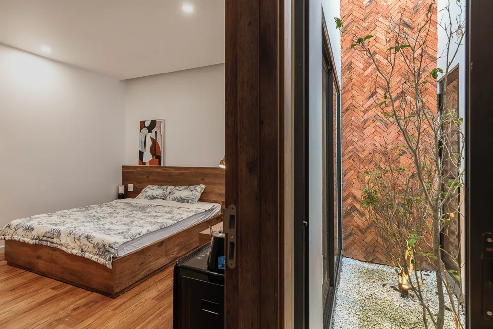 Phòng ngủ kết nối với giếng trời khiến không gian này thông thoáng và mát mẻ.