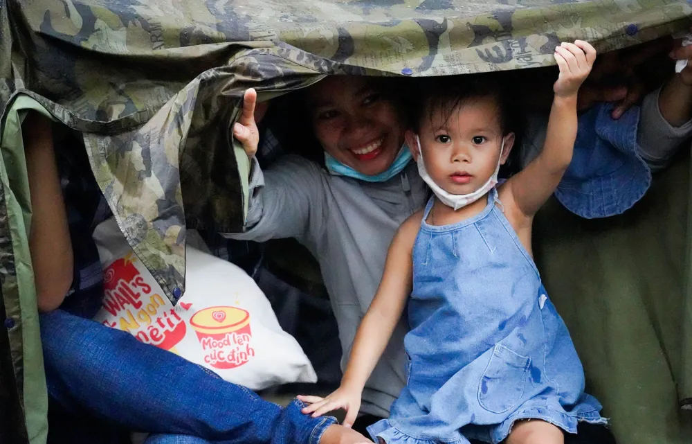 Giữa trưa cơn mưa nhỏ lướt qua, các gia đình tìm cách trú mưa.