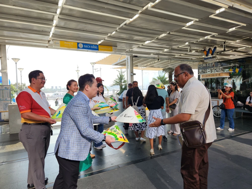 Ông Lê Trương Hiền Hòa, Phó Giám đốc Sở Du lịch TP.HCM tặng nón lá lưu niệm cho du khách Ấn Độ.