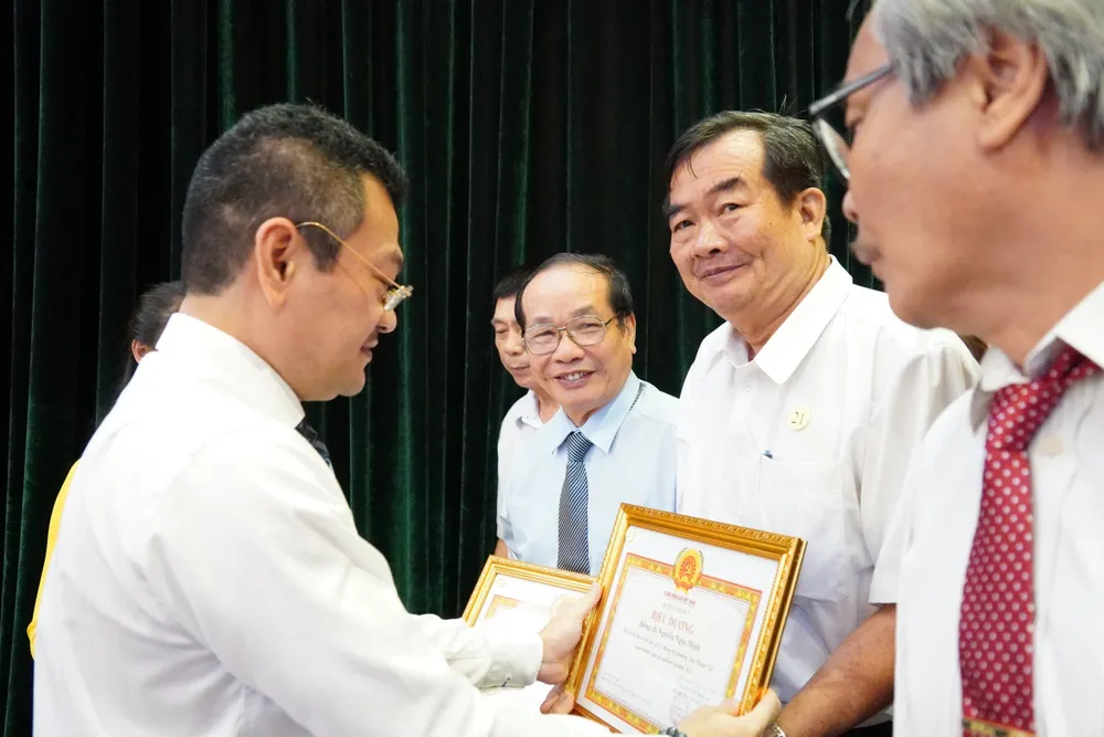 Ông Hoàng Minh Tuấn Anh, Chủ tịch UBND quận 7 trao tặng bằng khen cho các tập thể có thành tích cao năm 2023. Ảnh: THU TRINH.