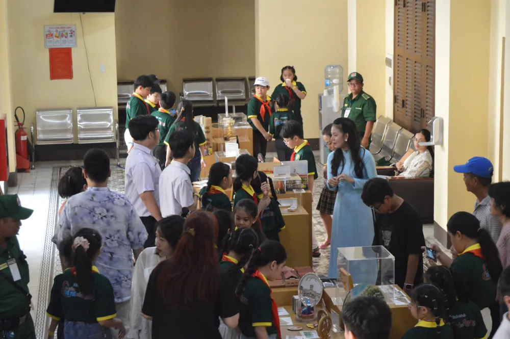 Khách tham quan và mua sắm quà lưu niệm trong chương trình tour tham quan di tích kiến trúc nghệ thuật cấp quốc gia trụ sở HĐND và UBND TP.HCM. Ảnh: THU TRINH.