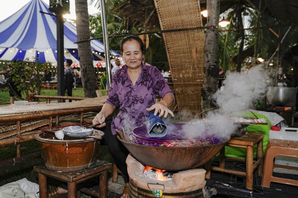 Tại gian hàng món bánh dân gian, du khách trải nghiệm học gói lá, học làm bún, đan nón, tráng bánh tráng... Ảnh: TT. am-thuc-3.jpg