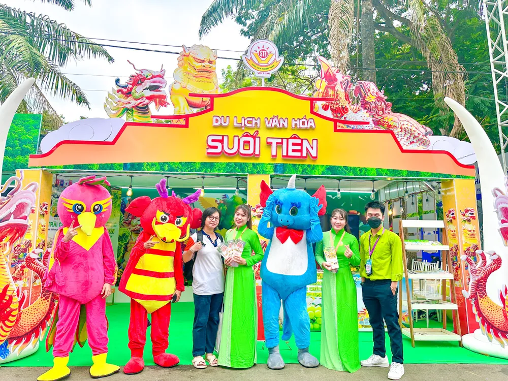 Du khách check in với hình ảnh linh vật Long, Lân, Quy, Phụng tại gian hàng Khu Du lịch Văn hóa Suối Tiên. Ảnh: TT du-lich-3.jpg