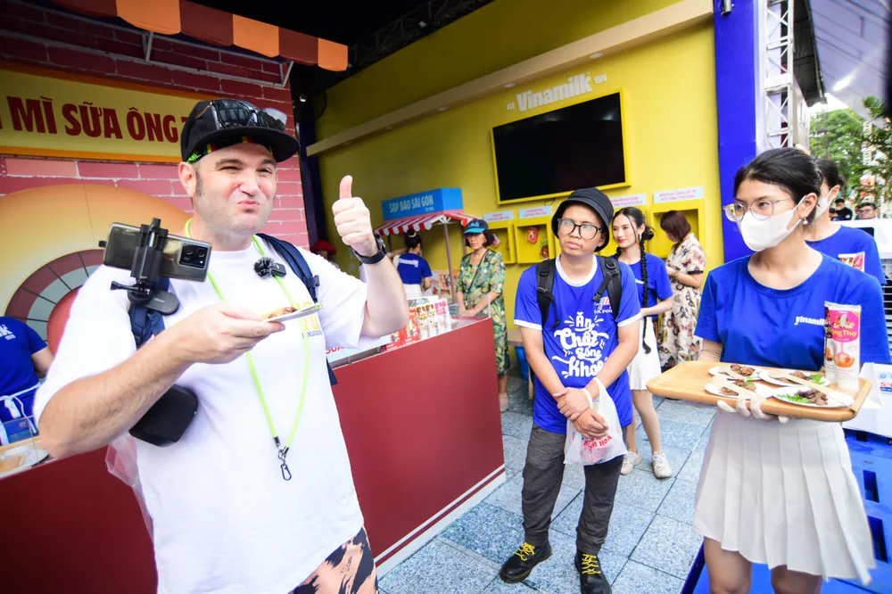 Du khách quốc tế thưởng thức bánh mì chấm sữa tại lễ hội bánh mì Việt Nam tại TP.HCM. Ảnh: TT.