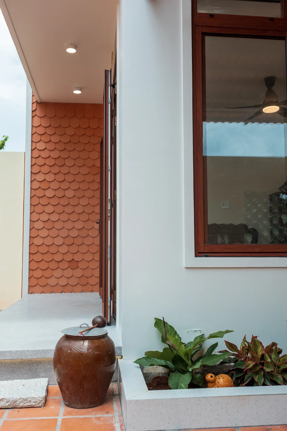 Những vật dụng mang ý nghĩa truyền thống như chiếc lu được bày trí trong khuôn viên sân nhà. ngoi-nha-hien-dai-17.jpg