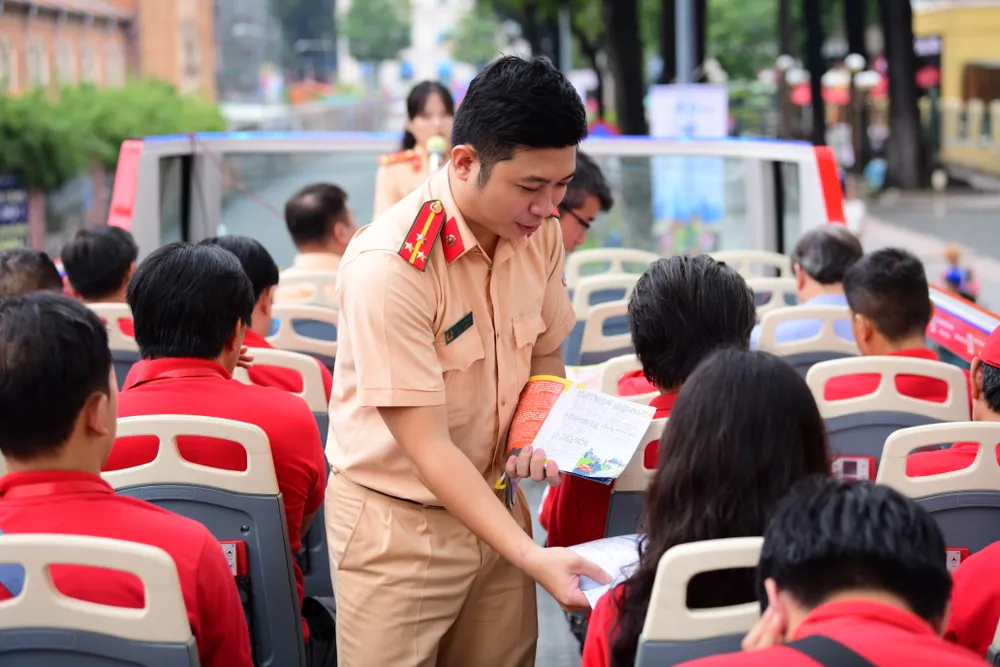 Cán bộ CSGT phát tài liệu kiến thức an toàn giao thông. Ảnh: TT. buyt-hai-tang-2.JPG