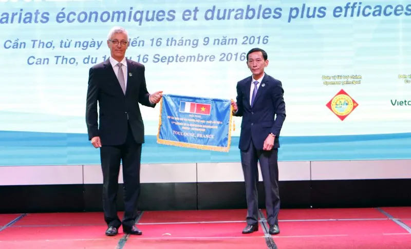 Chủ tịch UBND TP Cần Thơ Võ Thành Thống (bìa phải) trao cờ đăng cai Hội nghị lần thứ 11 cho đại diện TP Toulouse 