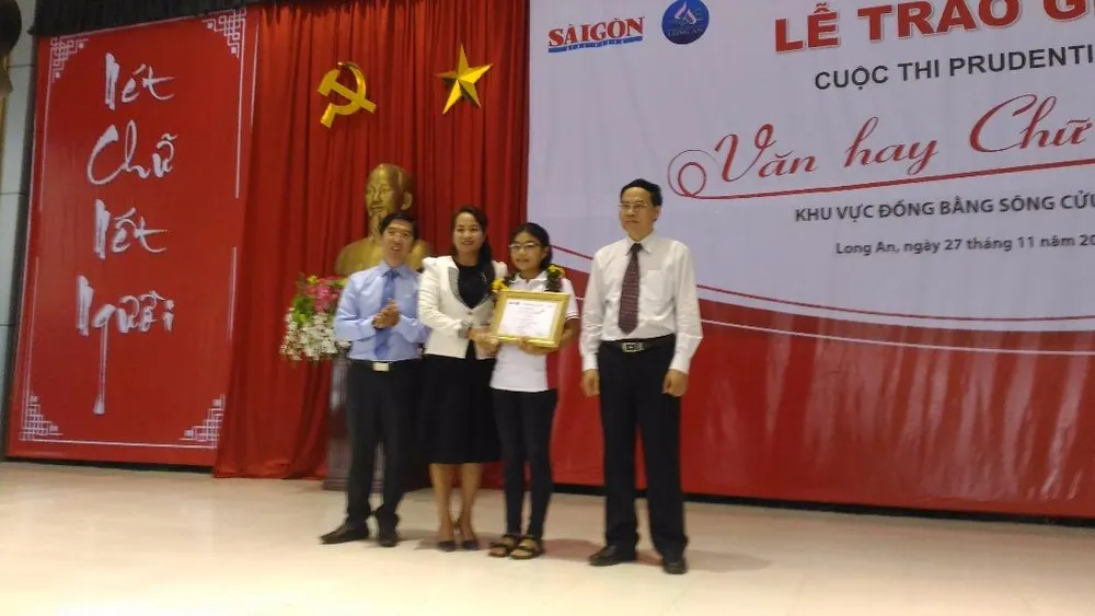 Ban tổ chức trao giải nhất khối 8-9 cho em Nguyễn Ngọc Trúc học sinh Trường thực hành sư phạm Trà Vinh. Ảnh: N.NAM