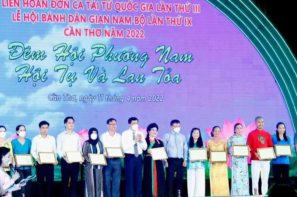Đại diện lãnh đạo TP Cần Thơ trao giấy chứng nhận đạt huy chương vàng tại hội thi làm bánh dân gian cho các nghệ nhân. Ảnh: NHẨN NAM