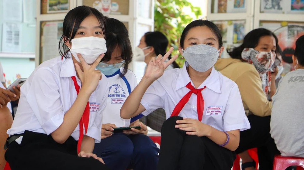 Đôi bạn vui vẻ tạo kiểu chụp hình sau khi đã tiêm xong. Ảnh: CHÂU ANH