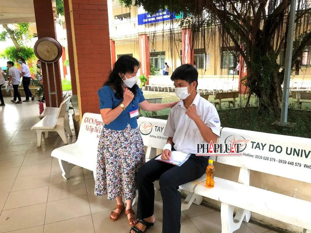 Cô dặn dò và động viên tinh thần cho Hùng trước khi vào phòng thi. Ảnh: NHẪN NAM