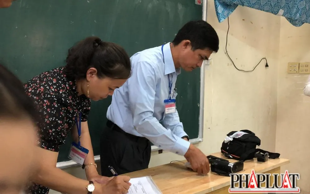 Lắp đặt thiết bị ghi hình để chuẩn bị cho TS làm bài thi. Ảnh: NHẪN NAM