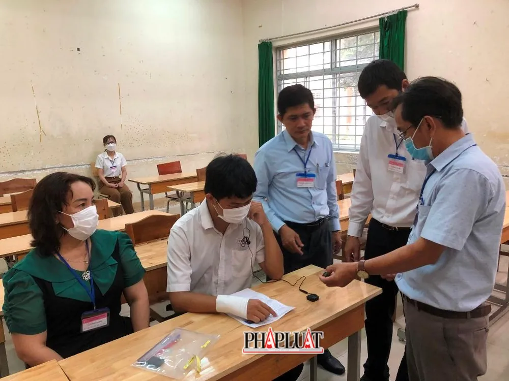Hướng dẫn cán bộ coi thi cách thức vận hành máy ghi âm để TS làm bài. Ảnh: NHẪN NAM
