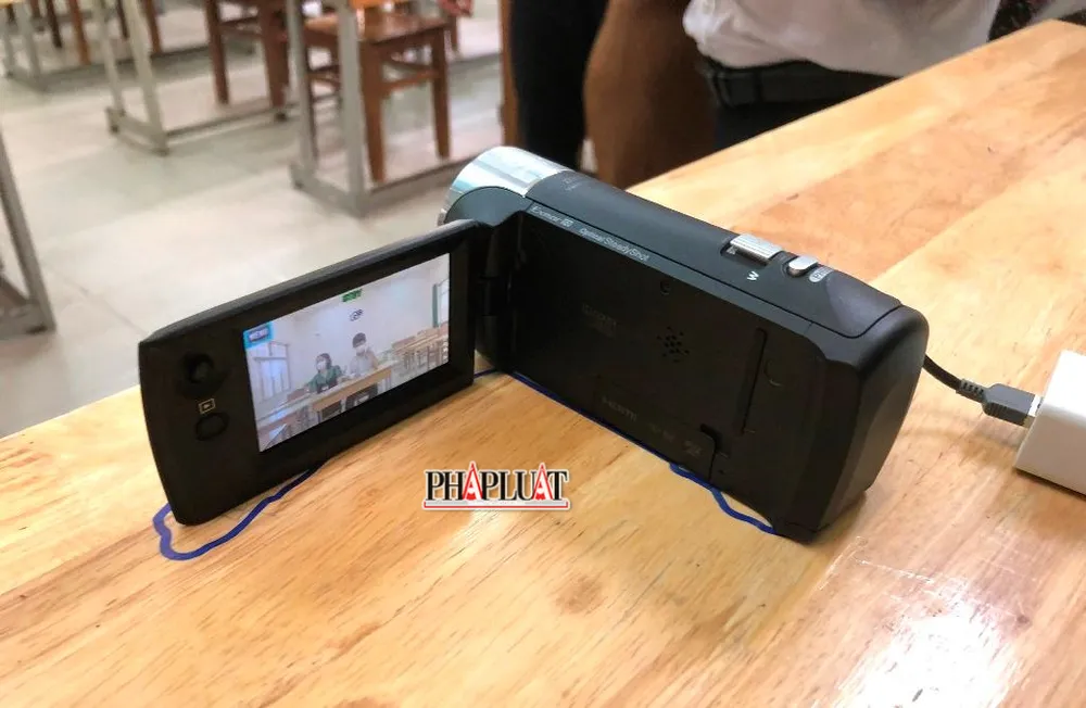 Máy ghi hình bắt trọn hình ảnh TS, cán bộ hỗ trợ và giám thị số 2 trong khung hình trong suốt thời gian TS làm bài thi. Ảnh: NHẪN NAM