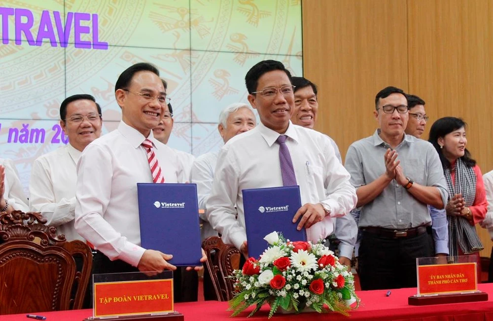 Phó Chủ tịch UBND TP Cần Thơ Nguyễn Thực Hiện (hàng trên, bìa phải) trao đổi bản ký kết với ông Trần Đoàn Thế Duy,Phó Chủ tịch HĐQT Tập đoàn Vietravel. Ảnh: NHẪN NAM