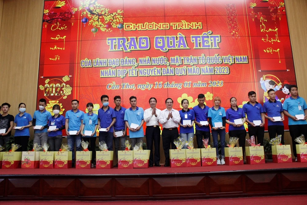 Phó Chủ nhiệm Văn phòng Chủ tịch nước Phạm Thanh Hà và Chủ tịch UBND TP Cần Thơ Trần Việt Trường trao quà cho công nhân. Ảnh: NHẪN NAM