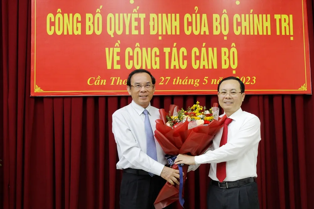 Bí thư Thành ủy TP.HCM Nguyễn Văn Nên trao hoa chúc mừng tân Bí thư Thành ủy Cần Thơ Nguyễn Văn Hiếu. Ảnh: NHẪN NAM