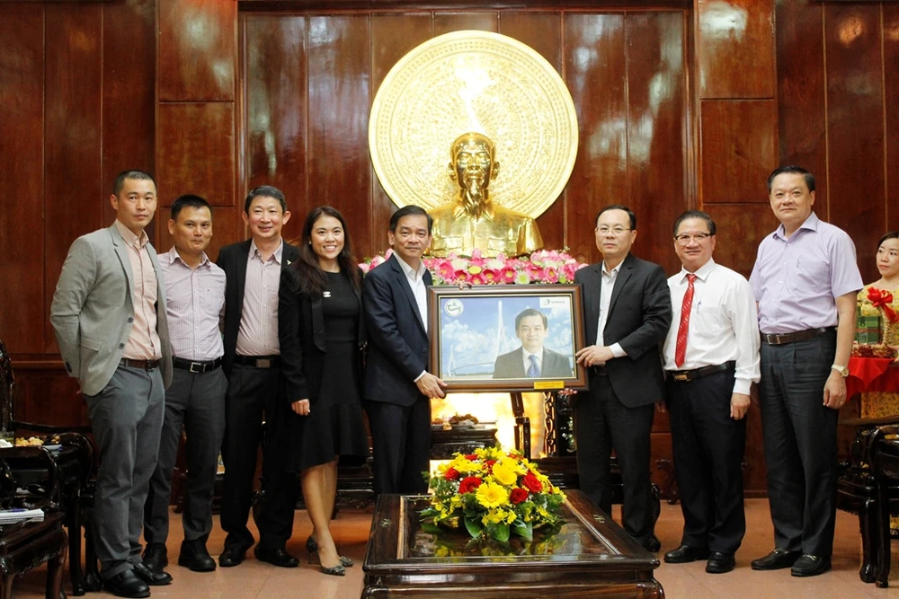 Lãnh đạo TP Cần Thơ tặng ông Kelvin Teo bức tranh chân dung làm từ gạo. Ảnh: NHẪN NAM