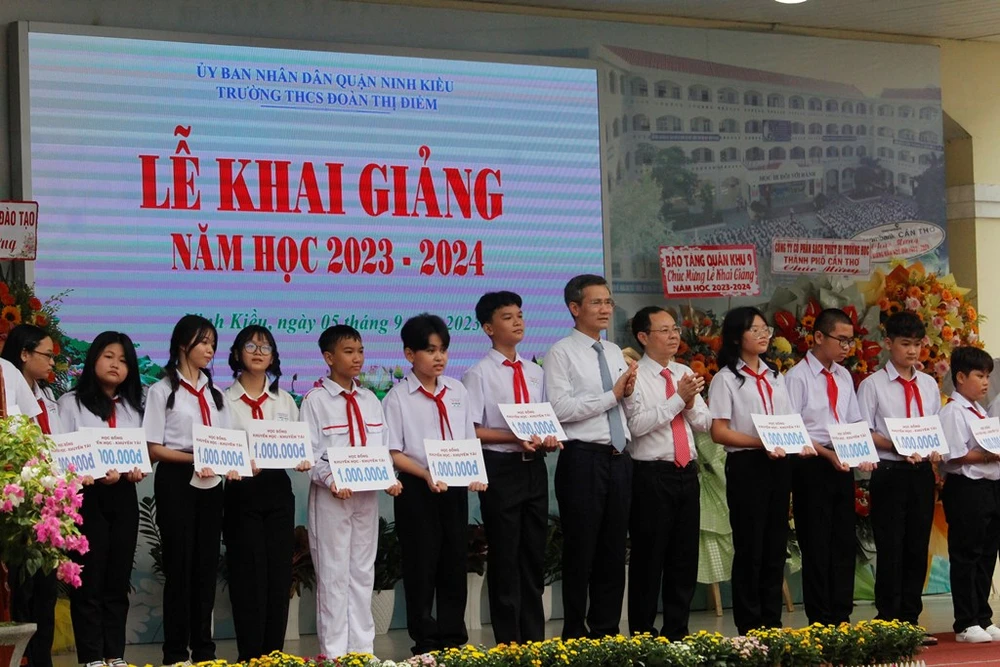 Bí thư Thành ủy Cần Thơ cùng lãnh đạo Văn phòng Chính phủ trao tặng học bổng cho học sinh Trường THCS Đoàn Thị Điểm tại lễ khai giảng. Ảnh: NHẪN NAM