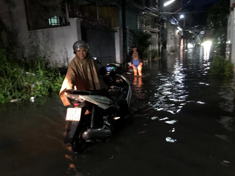 Người dân dắt xe trở lại khi thấy hẻm ngập nước quá sâu, không thể chạy qua. Ảnh: NHẪN NAM mua-ngap-duong-1.jpg