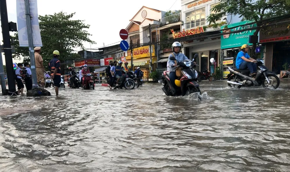 Lực lượng chức năng chốt ở một điểm triều cường dâng cao trên đường Cách Mạng Tháng Tám. Ảnh: NHẪN NAM trieu-cuong-can-tho-1.jpg