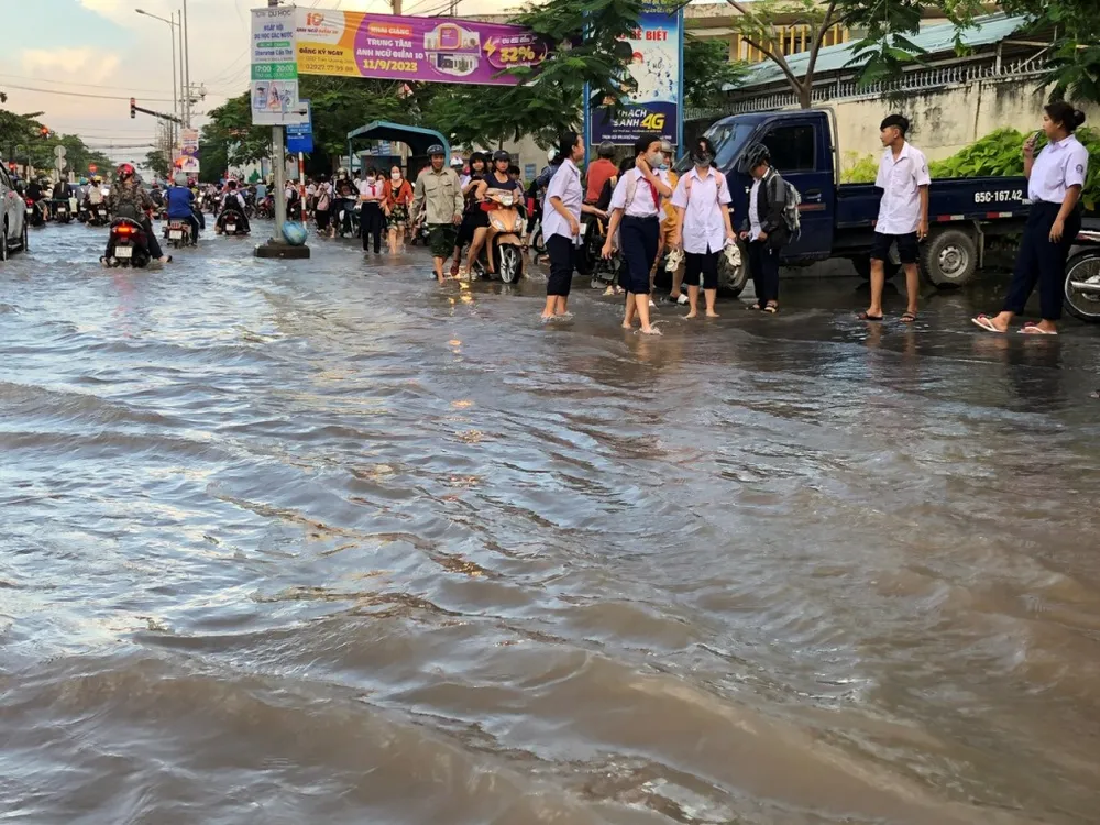 Nước lên đúng giờ tan học, nhiều học sinh phải lội nước về nhà. Ảnh: NHẪN NAM trieu-cuong-can-tho-2.jpg