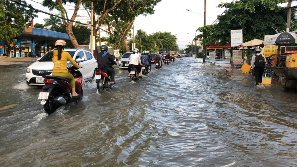 Để tránh vùng nước ngập sâu hai bên đường, người dân chọn cách đi chậm theo hàng dọc ở phần giữa đường. Ảnh: NHẪN NAM trieu-cuong-can-tho-4.jpg