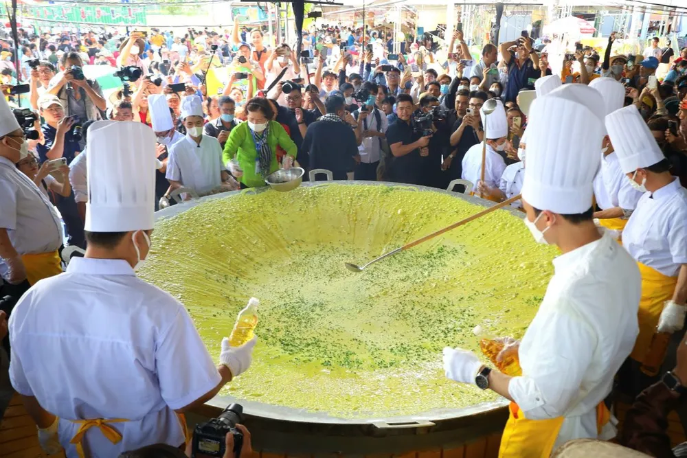 Các nghệ nhân, đầu bếp đổ chiếc bánh xèo khổng lồ trước sự chứng kiến của đông đảo người dân, du khách tại Lễ hội Bánh dân gian Nam bộ năm 2024. Ảnh: TP Bánh xèo khổng lồ chu vi 12 m tại Lễ hội Bánh dân gian Nam bộ năm 2024.