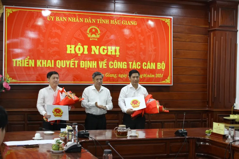 Chủ tịch UBND tỉnh Hậu Giang Đồng Văn Thanh trao quyết định và hoa chúc mừng ông Trần Lê Trung (bìa phải) và ông Nguyễn Trung Hậu. Ảnh: Minh Thuận. nhan-su-moi-tinh-hau-giang.jpg