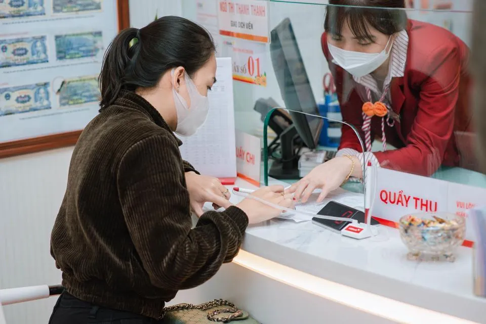 Khách hàng làm thủ tục tại quầy. Ảnh minh họa Khách hàng làm thủ tục tại quầy. Ảnh minh họa
