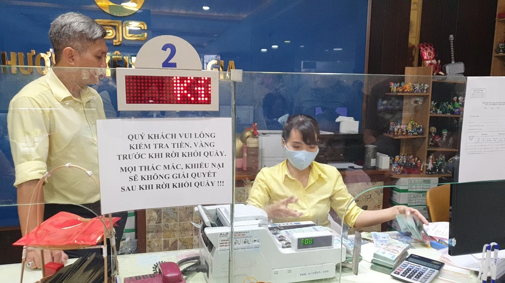Chênh lệch giữa vàng miếng SJC và thế giới ngày càng thu hẹp. Ảnh: T.L khách hàng bán vàng miếng.jpg