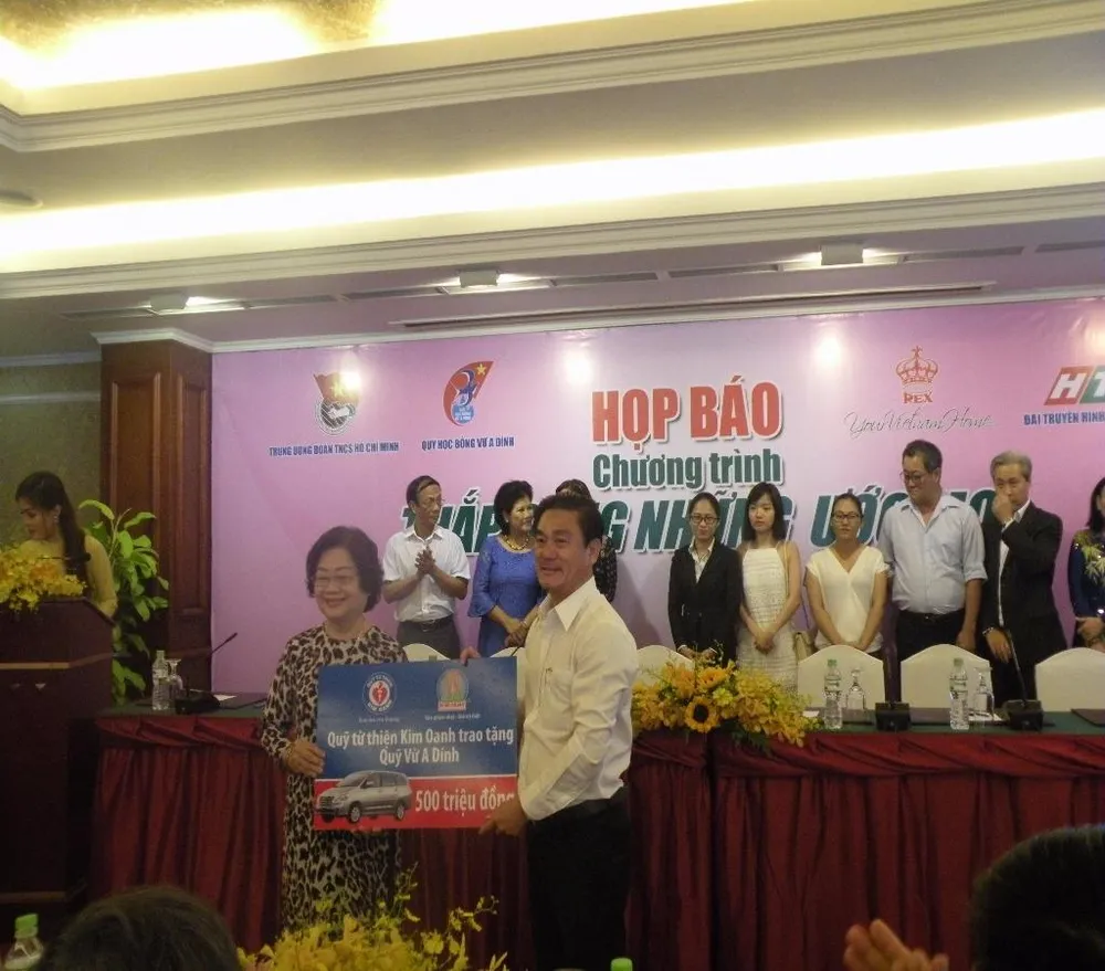 Bà Trương Mỹ Hoa, đại diện Qũy nhận quà tặng tượng trưng từ Qũy từ thiện Kim Oanh.