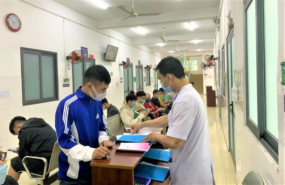 Nhân viên y tế hướng dẫn quy trình khám chữa bệnh tại BV Da liễu TP.HCM. Ảnh: THẢO PHƯƠNG