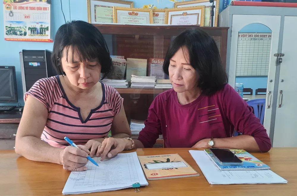 CTV dân số Tô Thị Tuyết Nhung (bìa phải) cập nhật tình hình biến động dân số trên địa bàn phụ trách mỗi ngày. Ảnh: TRẦN NGỌC CTV dân số Tô Thị Tuyết Nhung (bìa phải) cập nhật tình hình biến động dân số trên địa bàn phụ trách mỗi ngày. Ảnh: TRẦN NGỌC