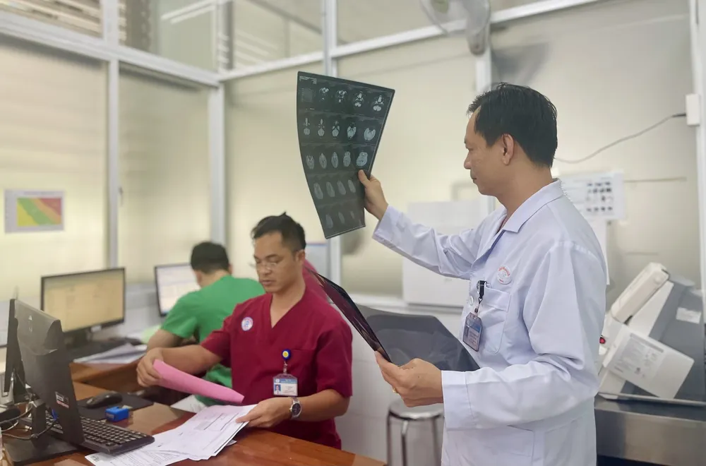 Bác sĩ CKII Trầm Minh Toàn kiểm tra các kết quả chụp chiếu của bệnh nhân. Ảnh: THẢO PHƯƠNG bac si tram minh toan benh vien cho ray.jpg
