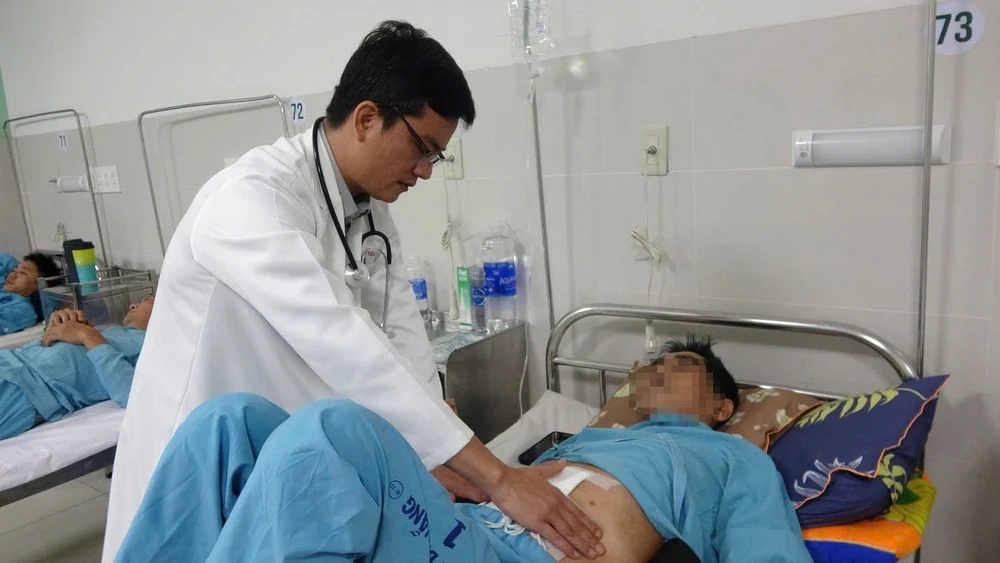 bác sĩ kiểm tra sau khi phẫu thuật khối u mỡ 15kg cho bệnh nhân