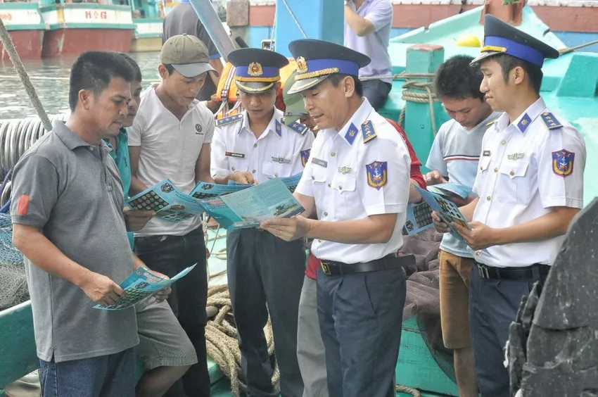 Lực lượng Vùng Cảnh sát biển 3 trực tiếp phát tờ rơi tuyên truyền các quy định tới ngư dân. Ảnh: TTXVN