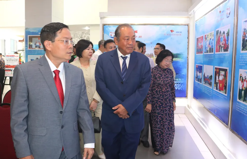 Các đại biểu tham quan triển lãm 3 năm chương trình một triệu lá cờ Tổ quốc cùng ngư dân bám biển. Ảnh: THÚY NHI