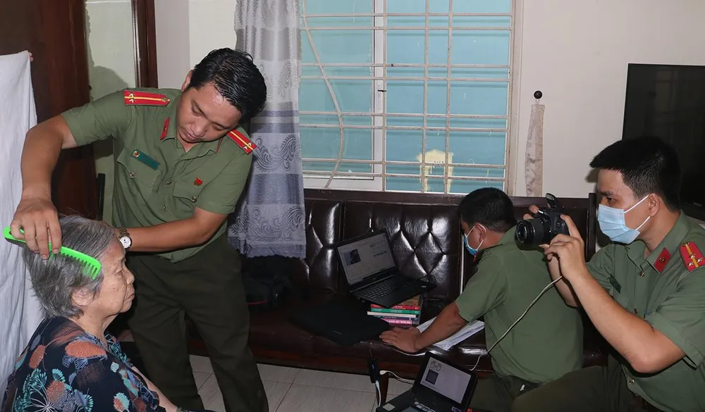 Công an thực hiện cấp CCCD gắn chip tại nhà cho cụ Trương Thị Truyền 95 tuổi, trên địa bàn phường 2, quận 3. Ảnh: THÚY NHI