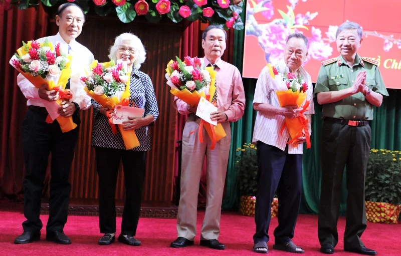 Bộ trưởng Tô Lâm tặng hoa chúc mừng các đồng chí cao tuổi tham dự buổi gặp mặt.