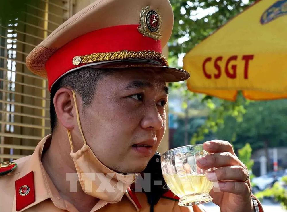 Sau ca trực dưới trời nắng gắt, da mặt của CSGT đen sạm vì cháy nắng. Ảnh: Phạm Kiên - TTXVN