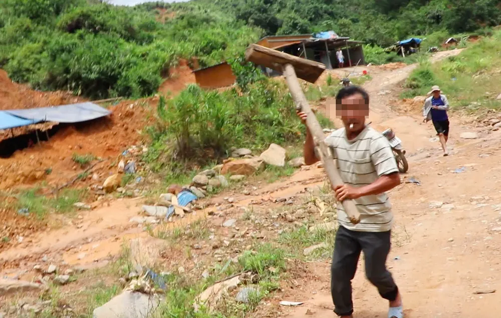 Một trong hai người cầm búa gỗ doạ hành hung phóng viên. Ảnh: TN dọa hành hung phóng viên
