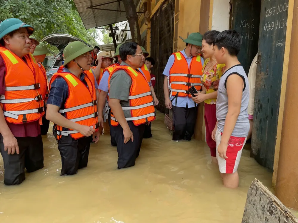 Thủ tướng Phạm Minh Chính vào khu dân cư thăm hỏi, động viên người dân tại xã Vân Hà, thị xã Việt Yên đang bị cô lập. Ảnh: VGP thu-tuong.jpg